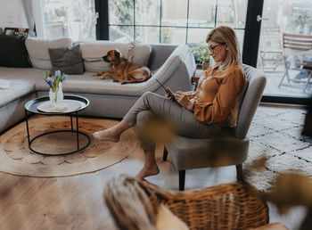 Woman with dog sitting at home