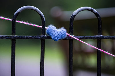 Close-up of rope tied to metal fence