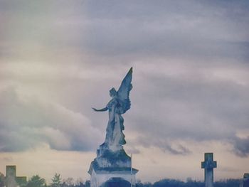Low angle view of statue against cloudy sky