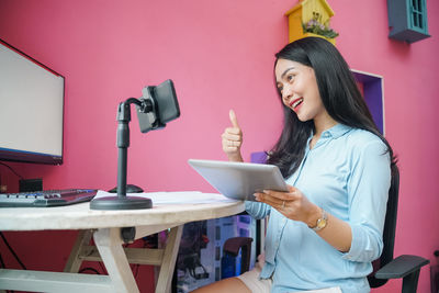 Young woman blogging at home