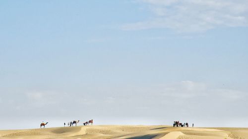 People on beach against sky