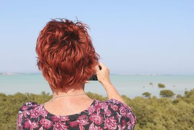 Woman standing by sea