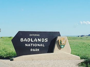 Information sign on land against sky