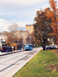 Street amidst trees and buildings in city against sky