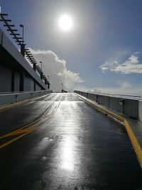 Road by bridge in city against sky