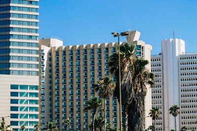 Low angle view of modern buildings against blue sky