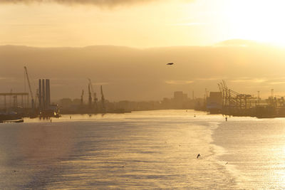 View of city at waterfront during sunset