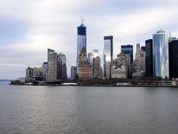 One world trade center by river against sky in city