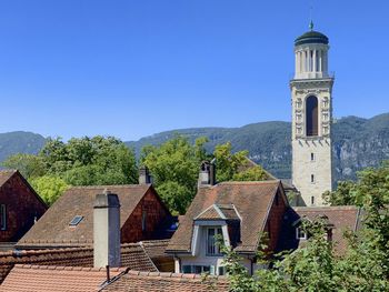 Panoramic view of buildings and mountains against blue sky