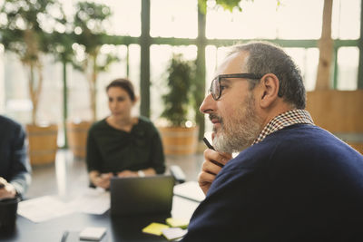 Concentrated mature businessman in meeting at creative office