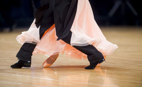 Low section of couple dancing on floor