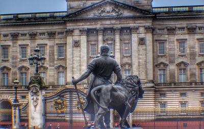 Statue against buildings in city