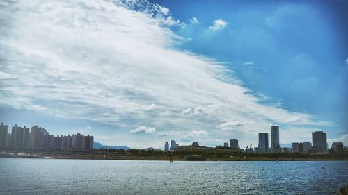 River in city against cloudy sky