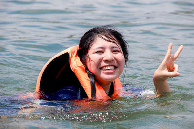 Portrait of smiling young woman in lake