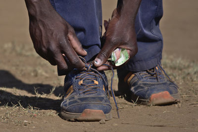 Low section of man wearing shoes