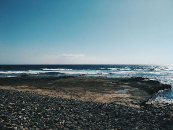 View of calm beach against blue sky