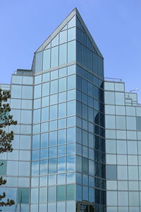 Low angle view of modern building against clear blue sky