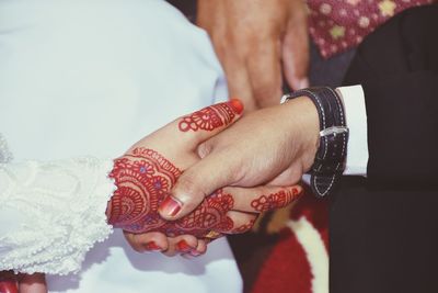 Midsection of couple holding hands