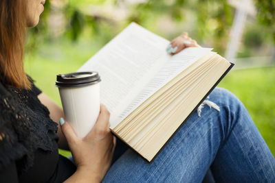 Midsection of woman reading book