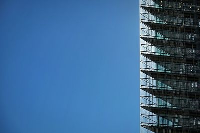 Low angle view of modern building against clear blue sky