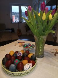 Various flowers in vase on table at home