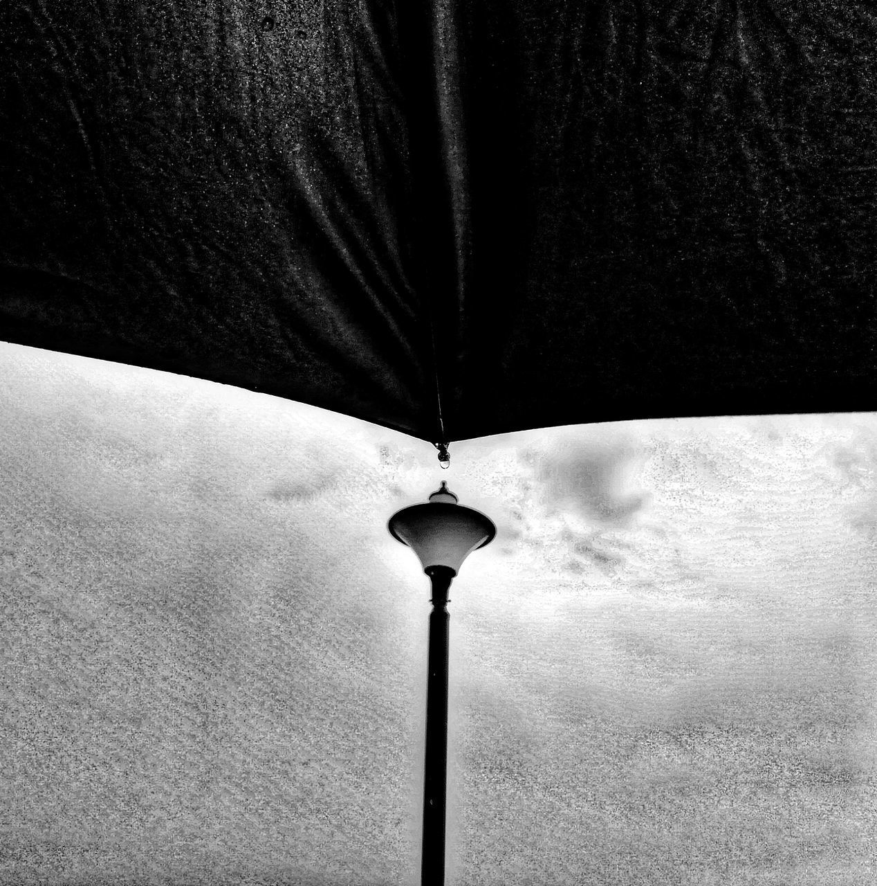 LOW ANGLE VIEW OF ILLUMINATED STREET LIGHT AGAINST WALL