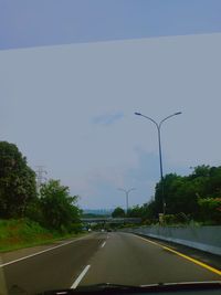 Road against sky seen through car windshield
