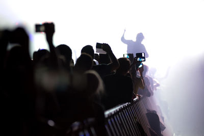 People standing by railing in music concert