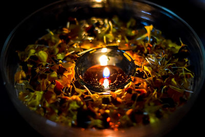 High angle view of lit candles in bowl
