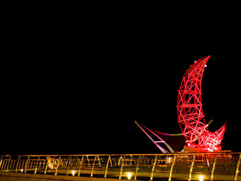 Low angle view of illuminated ferris wheel against sky at night