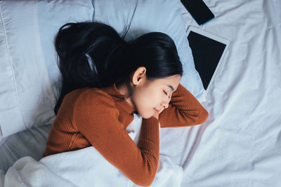 High angle view of woman lying on bed at home