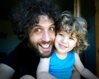 Portrait of happy father and son at home