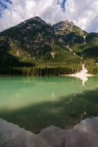 Scenic view of lake by mountain against sky