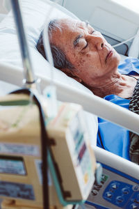 Senior man lying down in bed at hospital