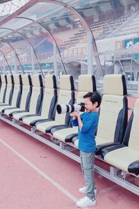 Full length of boy standing on bus