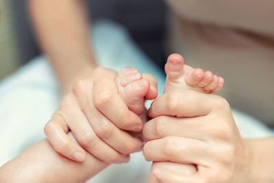 Close-up of mother massaging baby feet
