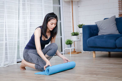 Young woman sitting on floor at home