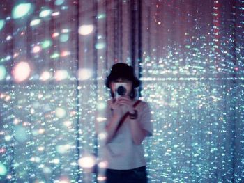 Portrait of woman photographing through camera