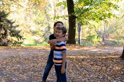 Full length of boy standing on street during autumn