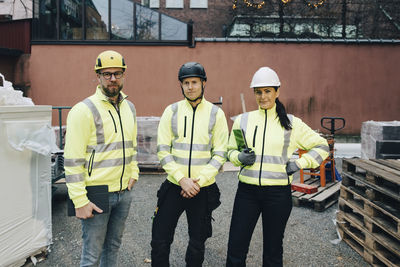 Portrait of male and female engineers standing together at construction site