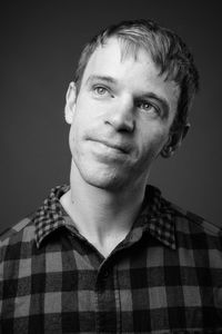 Portrait of young man against black background