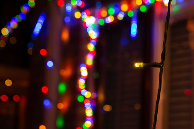 Festive season colourful christmas and new year lights shining at night with bokeh balls