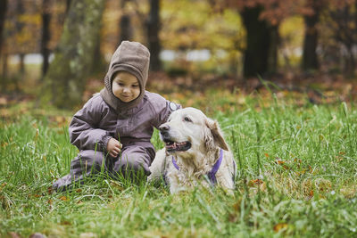 Portrait of young woman with dog on field