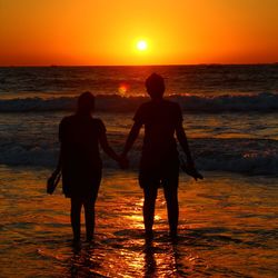 Silhouette of people at beach during sunset