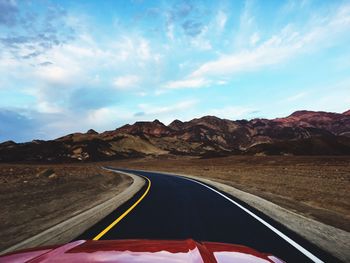 Road by mountain against sky