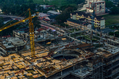 High angle view of crane amidst incomplete building in town