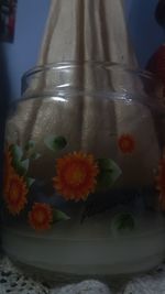 Close-up of orange flower in glass on table