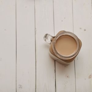 Close-up of coffee cup with wooden background 