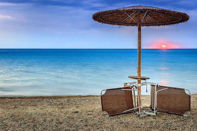 Traditional windmill on beach against sky