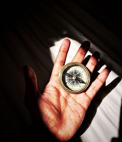 Cropped hand of person holding navigational compass